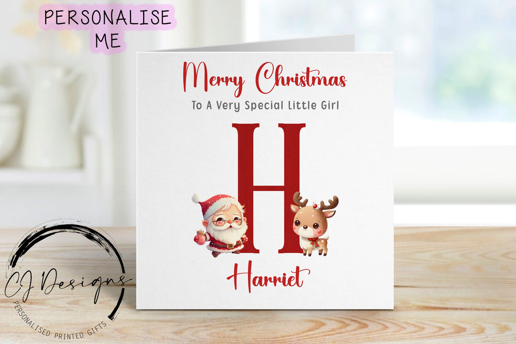 Little Girl christmas card with a picture of santa with his reindeer and a large single red letter which depicts thefirst letter of the childs name