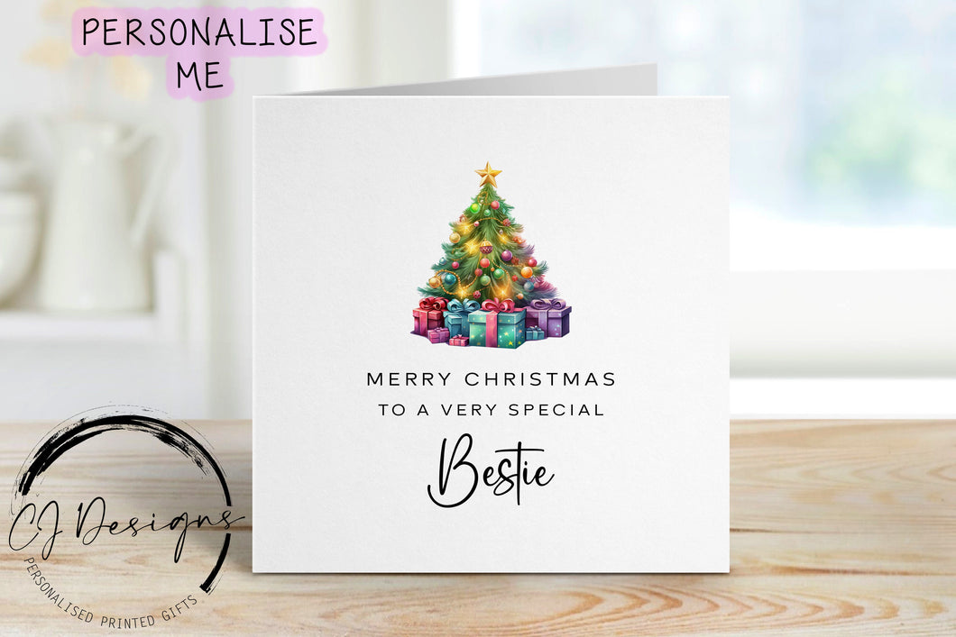 Bestie chirstmas card with a picture of a colourful Christmas tree with gifts underneath
