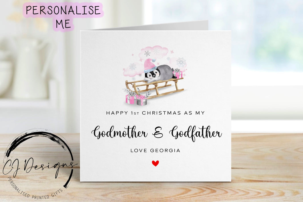 Little Girl First Christmas as my Godmother & Godfather personalised christmas card in a pink theme with picture of baby penguin wearing a pink christmas hat on a sledge