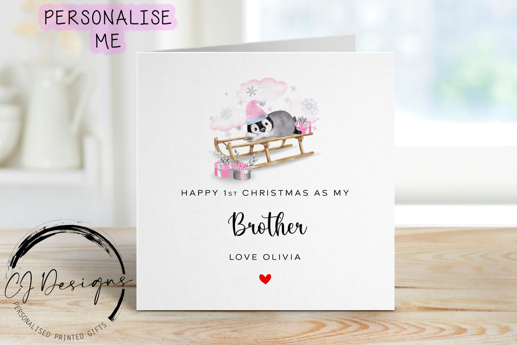 Little Girl First Christmas as my Brother personalised christmas card in a pink theme with picture of baby penguin wearing a pink christmas hat on a sledge