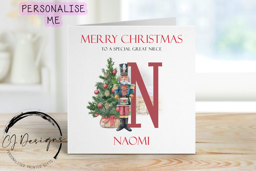 Great Niece personalised Christmas card with a nutcracker with Christmas Tree sstood next to a large red letter which depicts the first letter of your little