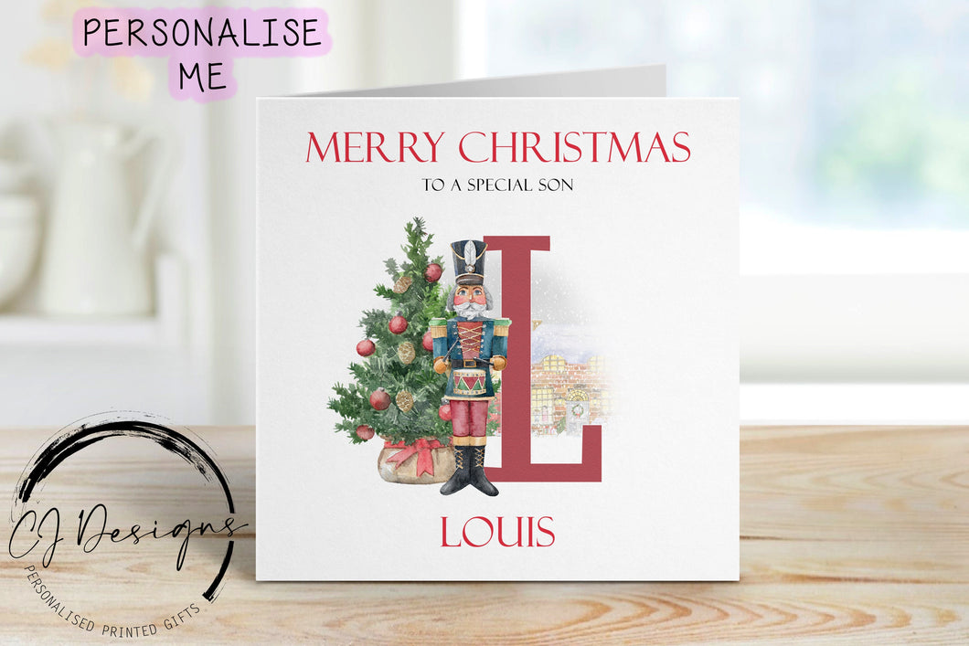 Son personalised Christmas card with a nutcracker with Christmas Tree sstood next to a large red letter which depicts the first letter of your little