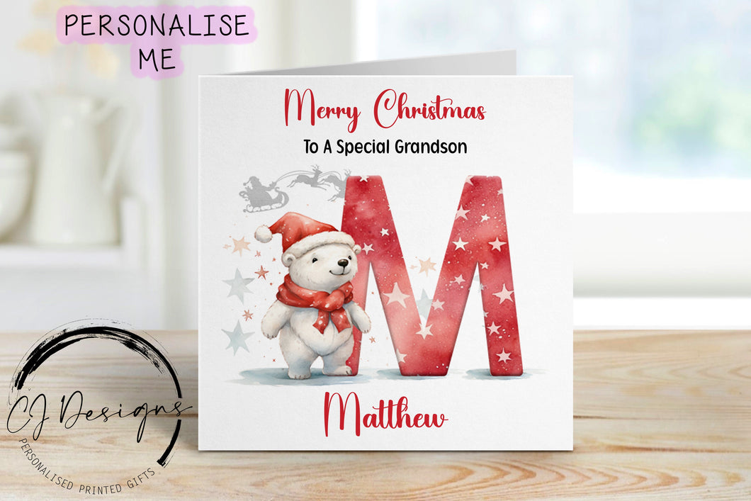 Grandson personalised Christmas card with a polarbear wearing a christmas hat stood next to a large red letter which depicts the first letter of your little ones name